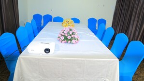 A conference room with a white table, blue chairs, and a projector. - Lan Tian International Hotel (Addis Ababa)