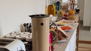 A kitchen with a toaster, a coffee maker, and various food items on the counter. - Guesthouse Stekkatún (Höfn)