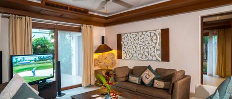 A living room with a television, sofa, coffee table, and decorative items.