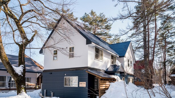 A two-story building with a blue exterior and a sloped roof, surrounded by snow and trees. - Sumi Villa Hakuba (Hakuba)
