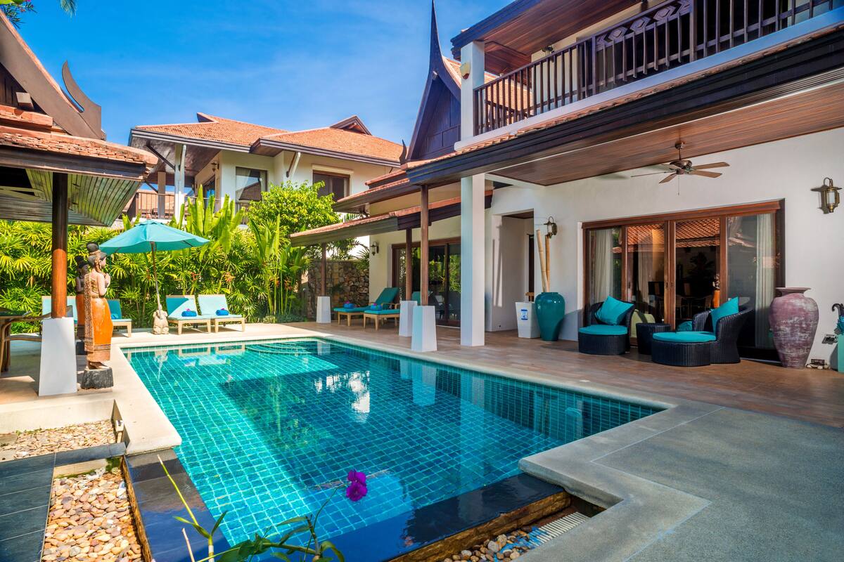 A swimming pool with lounge chairs and a covered patio area.