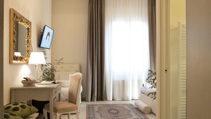 Una camera d'hotel con scrivania, sedia, letto e vista sull'esterno.