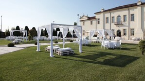 Location per matrimoni all'aperto con tende bianche, tavoli e sedie disposti su un prato.