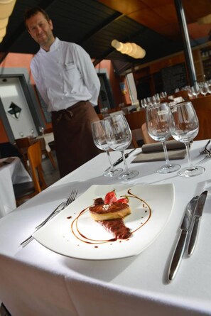 A dining table with a dessert plate, wine glasses, and cutlery. - La Clef d'Or (Bursinel)