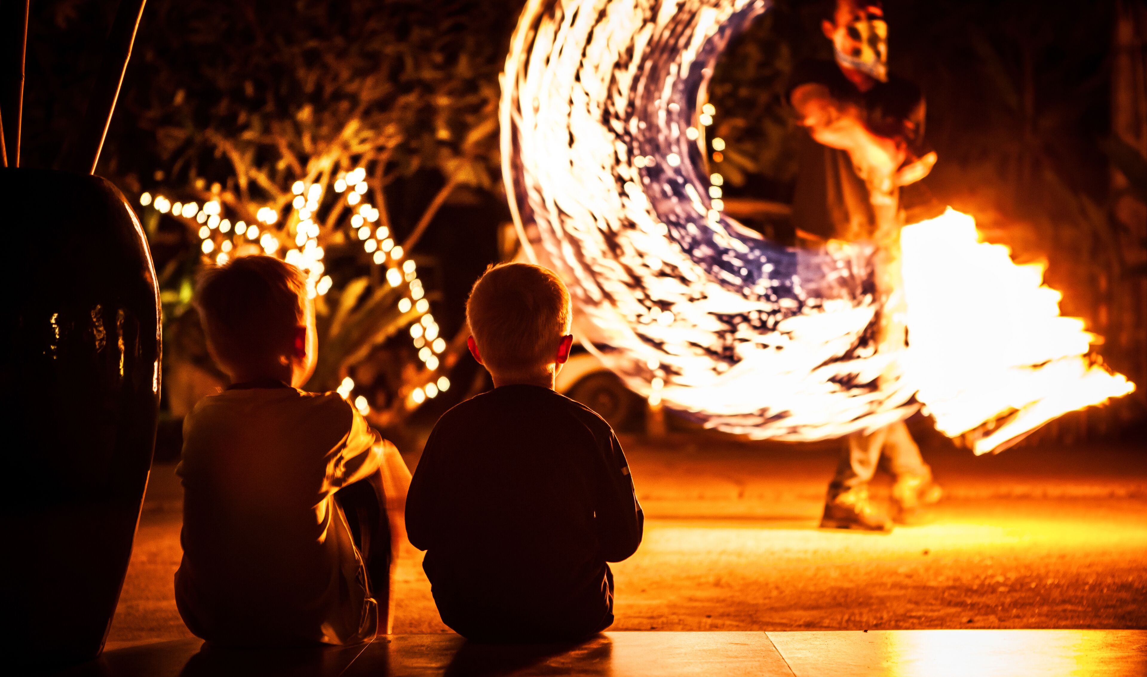 Two children watching a fire performance.