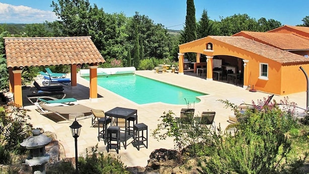 A pool area with lounge chairs and a gazebo, surrounded by greenery and a clear sky. - Villa Colibri (Lorgues)