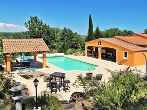 A pool area with lounge chairs and a gazebo, surrounded by greenery and a clear sky. - Villa Colibri (Lorgues)