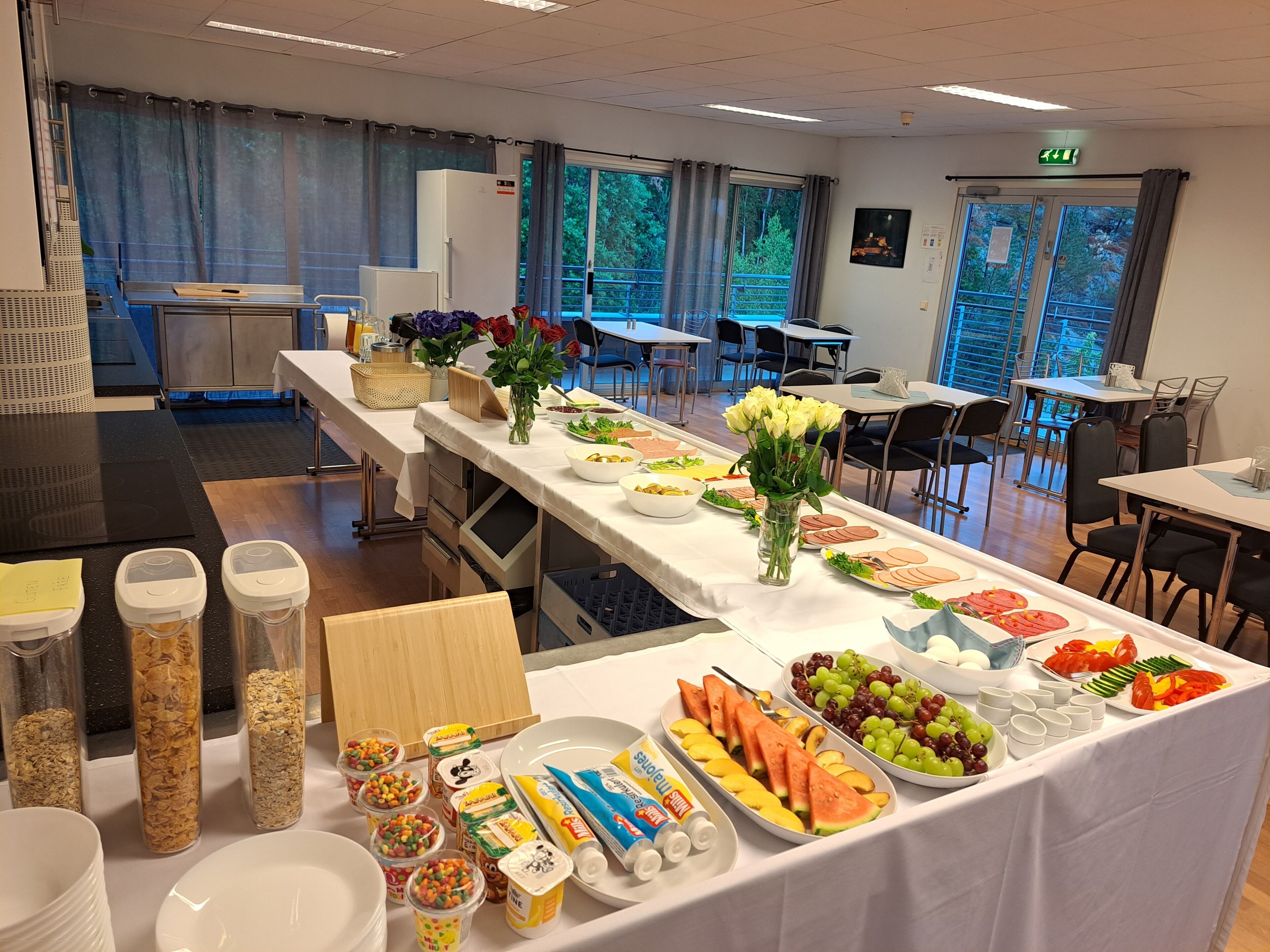 A buffet setup with various food items and a long table.