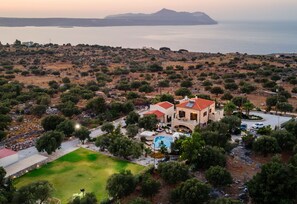 A coastal property with a swimming pool, a tennis court, and a view of the sea and a mountain in the background. - Villa Freedom (Apokoronas)