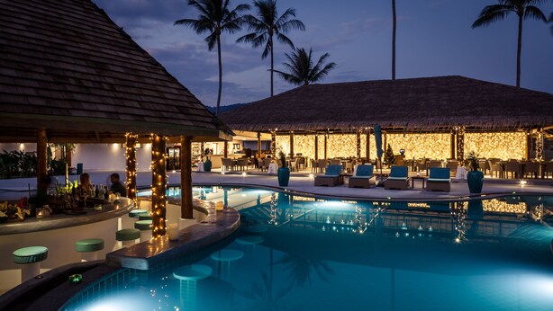 A poolside area with lounge chairs, a bar, and a restaurant. - Baan Tawan (Koh Samui)