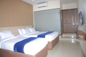 Una habitación de hotel con dos camas, televisión y minibar.