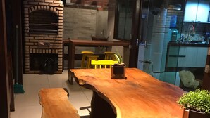Een moderne keuken met een ingebouwde bakstenen oven, een houten bar en krukken.