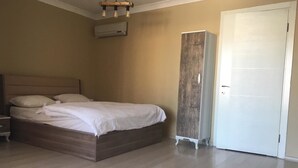 Un dormitorio con una cama de madera, un armario y una puerta blanca.