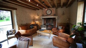 Un salon de style rustique, avec des canapés en cuir, une cheminée et un plafond en bois.