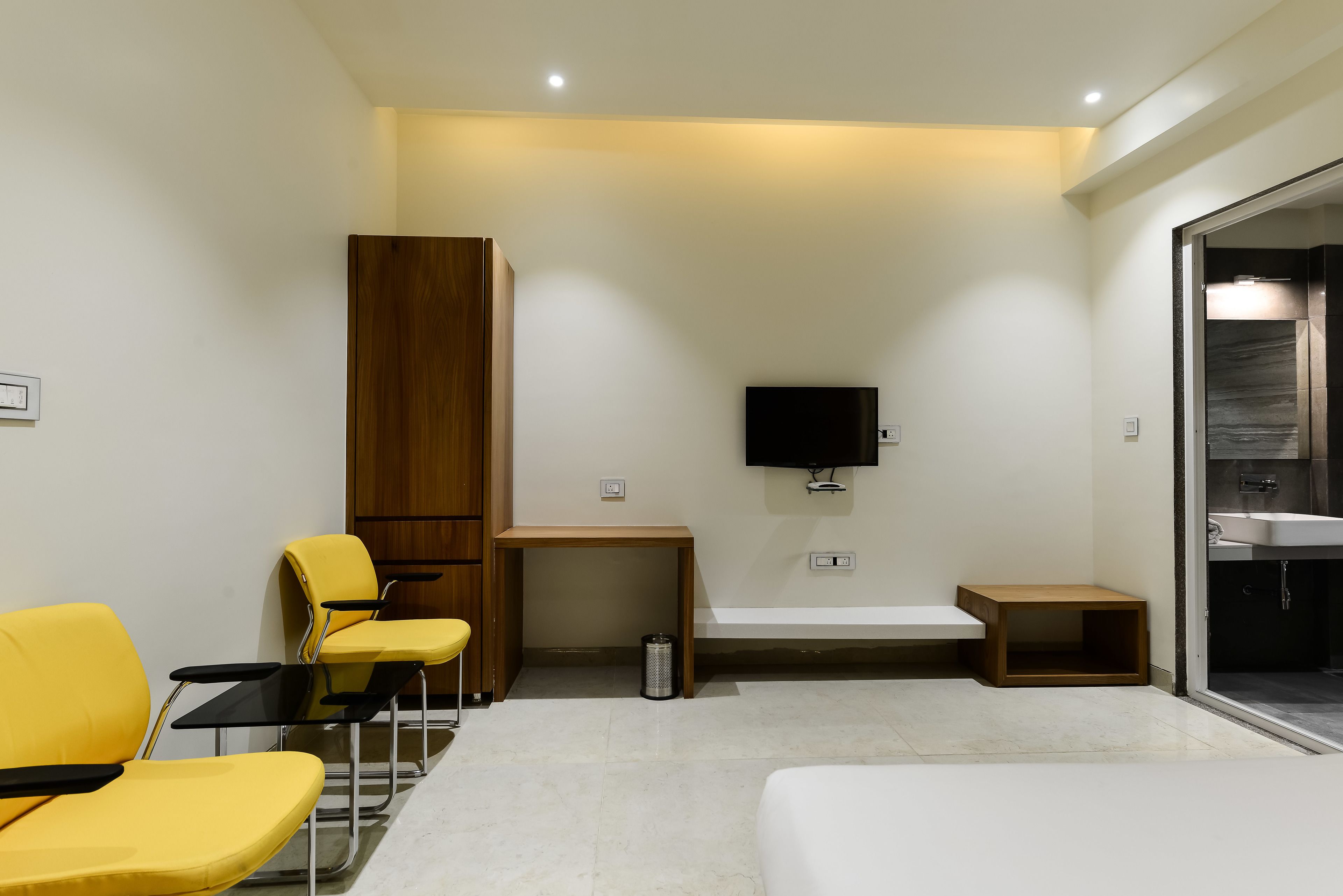 Een moderne hotelkamer met een bed, een bureau, een televisie en een badkamer.