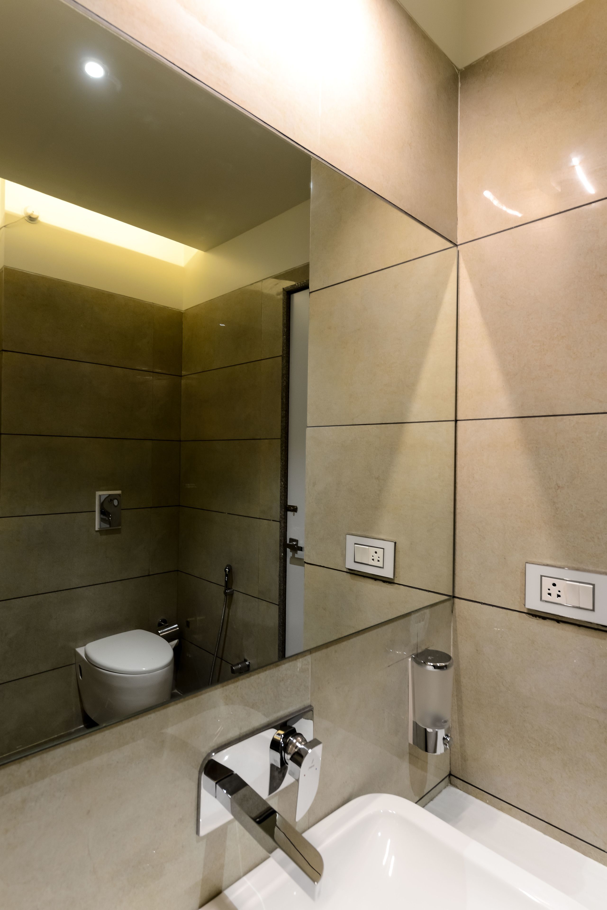 A modern bathroom with a large mirror, a toilet, a shower, and a bathtub.