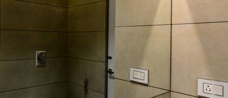 A modern bathroom with a large mirror, a toilet, a shower, and a bathtub.