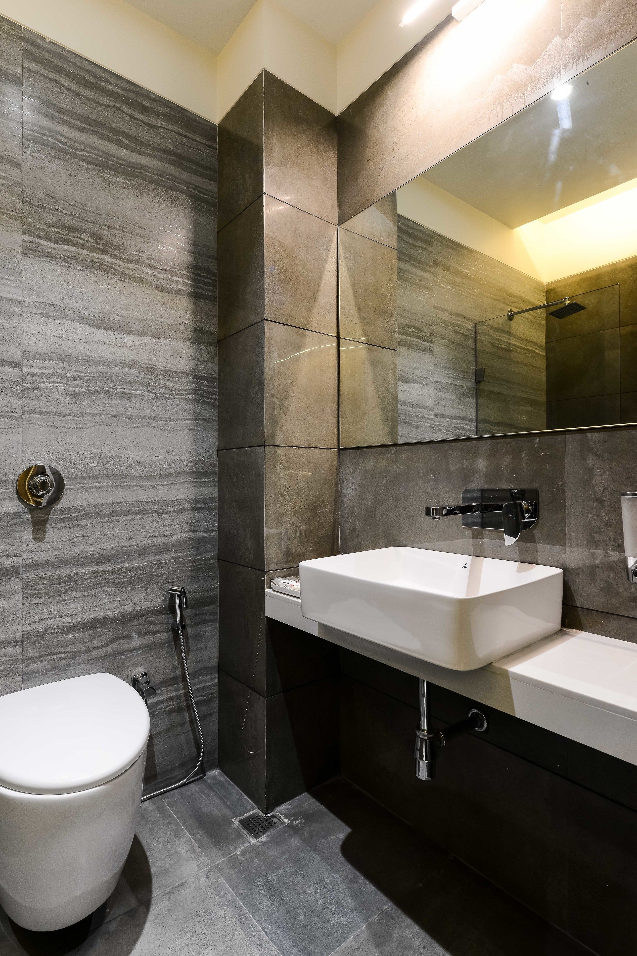 A modern bathroom with a toilet, a sink, and a shower.