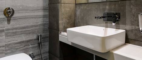 A modern bathroom with a toilet, a sink, and a shower.