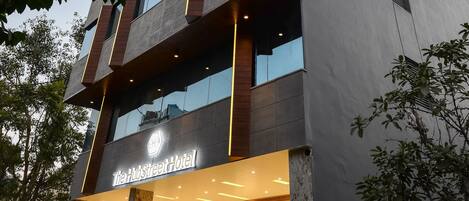 Un hotel moderno con una entrada destacada, amplias ventanas y una fachada bien iluminada.