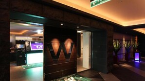 The entrance to a hotel with a modern design, including a reception desk and a sign indicating the entrance area. - HOTEL W - Adults Only (Koshigaya)