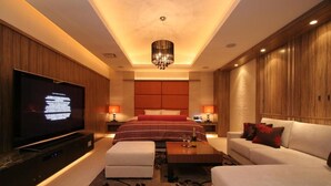A modern hotel room with a large flat-screen TV, a comfortable bed, a sofa, and a coffee table. - HOTEL W - Adults Only (Koshigaya)
