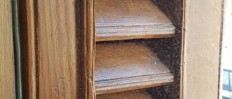 A wooden door with a vertical handle and a glass panel.