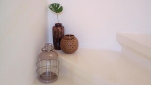 A staircase with a handrail, a potted plant, and two decorative vases. - Squadron Base (Luqa)
