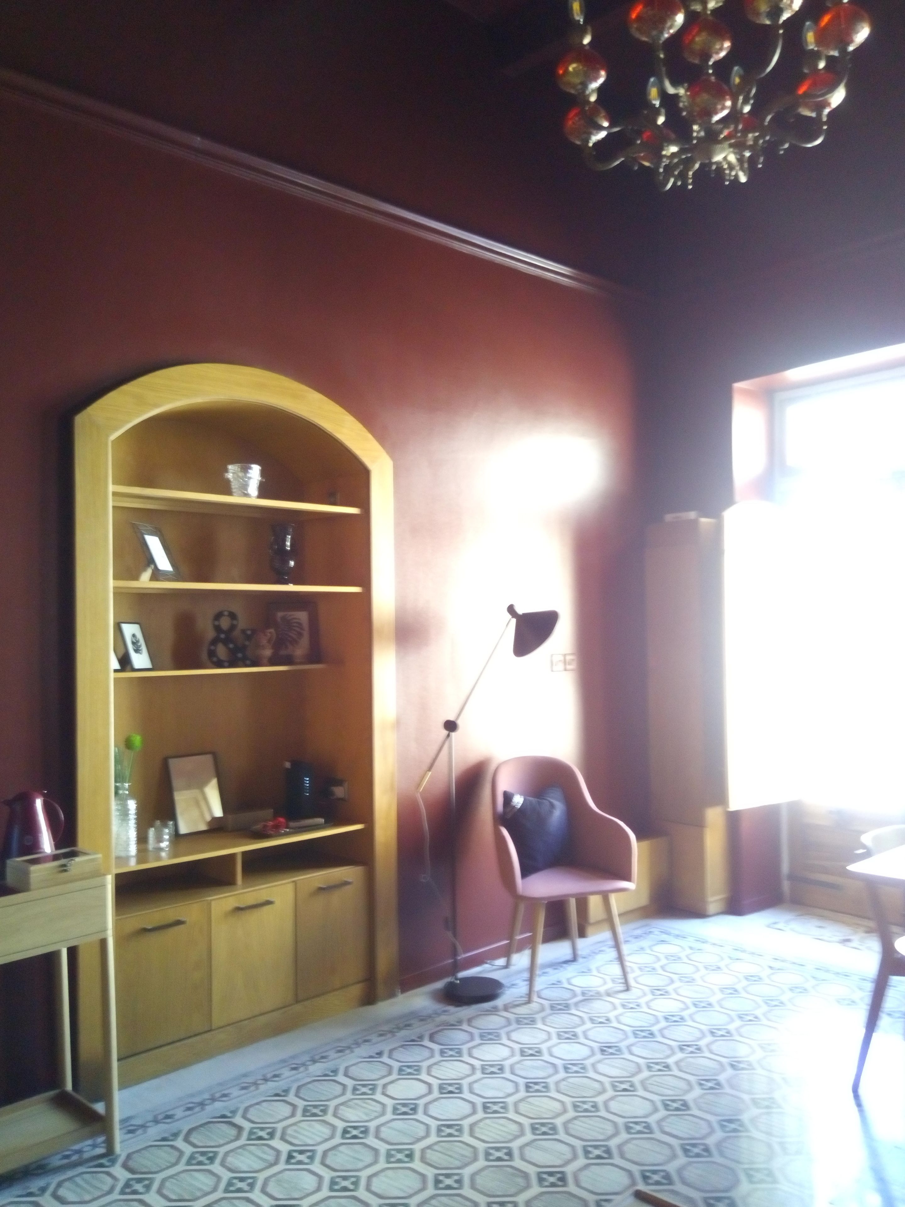 Una stanza con una libreria in legno, una scrivania, una sedia e un pavimento decorato.