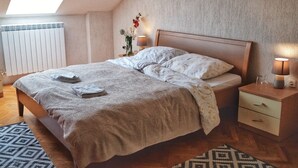 A bedroom with a bed, bedside tables, a radiator, and a skylight. - Apartments Patricija (Opatija)