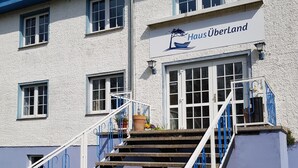 Un edificio con un cartel que dice "Haus Überland" y una escalera que conduce a la entrada.