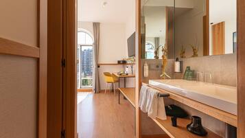 Un bagno moderno con un mobile bagno in legno, uno specchio e vista sulla città.