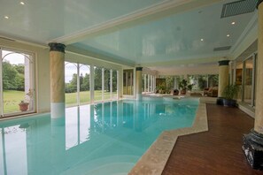 Een binnenzwembad en ligstoelen