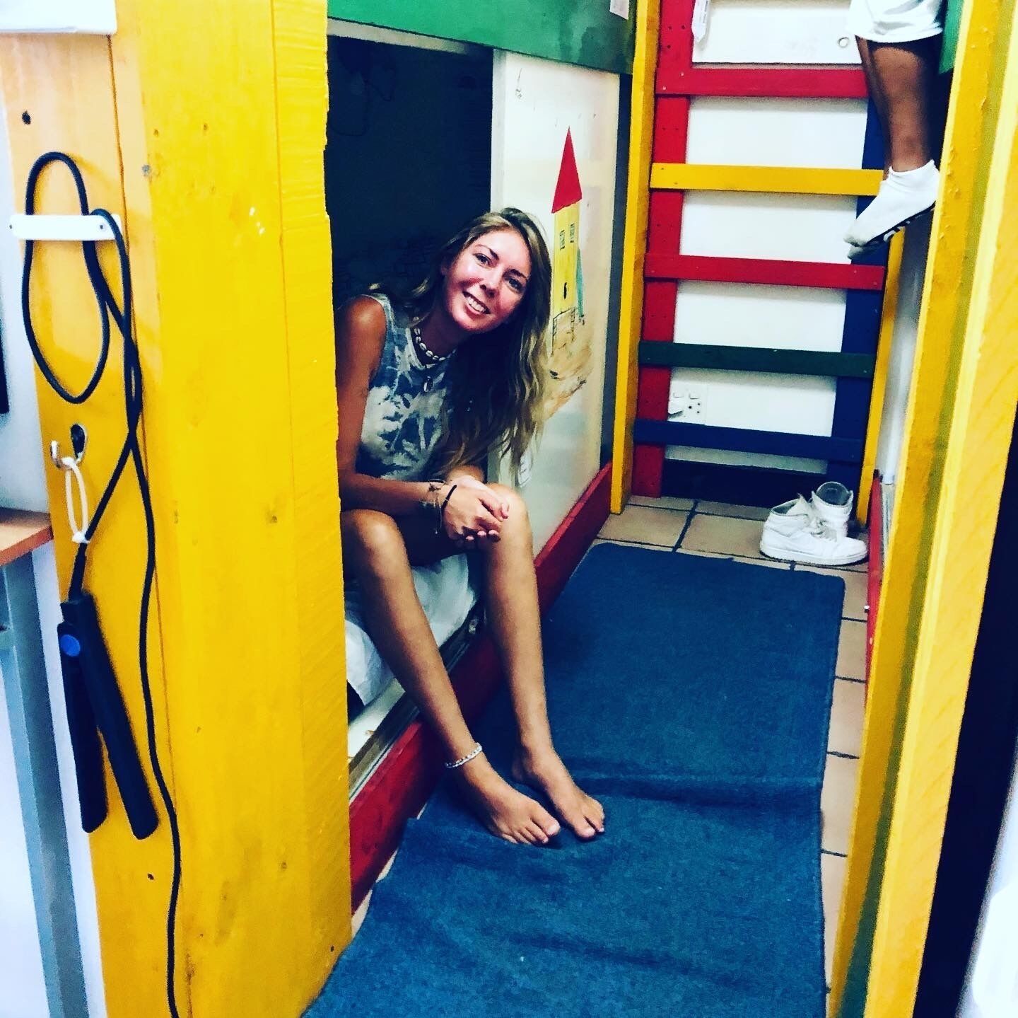 A narrow hallway with yellow walls and a blue mat on the floor.