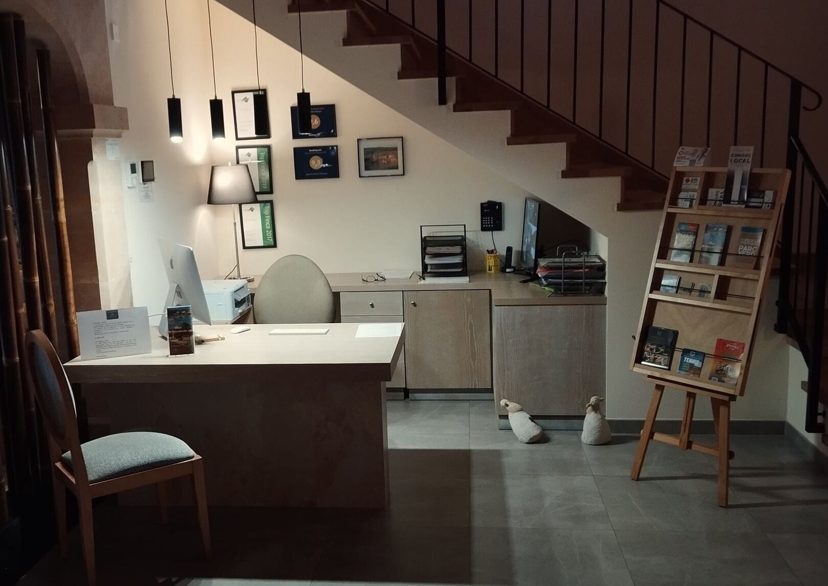 A modern office space with a desk, chair, and a bookshelf.