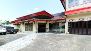 A building with a tiled roof and a paved entrance area. - Andrin Daspatt Hotel (Makassar)