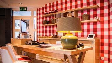 A checkered wall, a desk with a lamp, a computer, and a chair.
