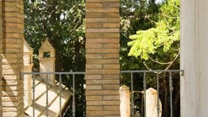 Une arche en pierre offrant une vue sur les arbres et donnant accès à un escalier.