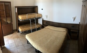 A room with a bunk bed, a single bed, a wooden wardrobe, and a tiled floor. - Agriturismo Aqua Viva (Acquaviva Picena)