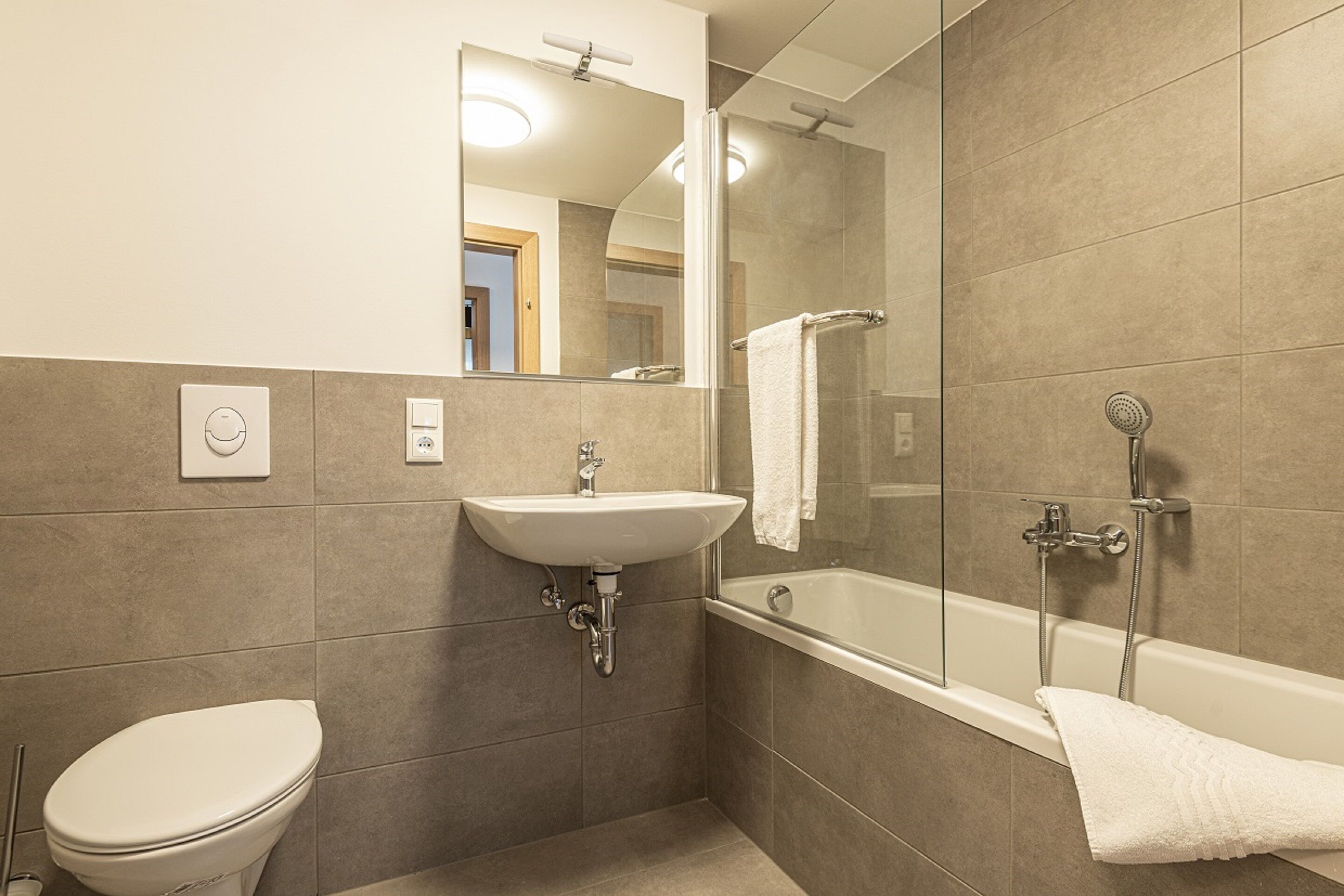 Un baño moderno con inodoro, lavamanos y bañera.