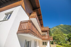 A two-story building with wooden balconies and a mountain view.