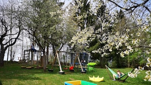 A playground with swings, a slide, and a swing set. - Pension Fernblick (Sankt Oswald-Riedlhuette)