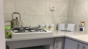 Ett kök med en gasspis, en mikrovågsugn och en brödrost.