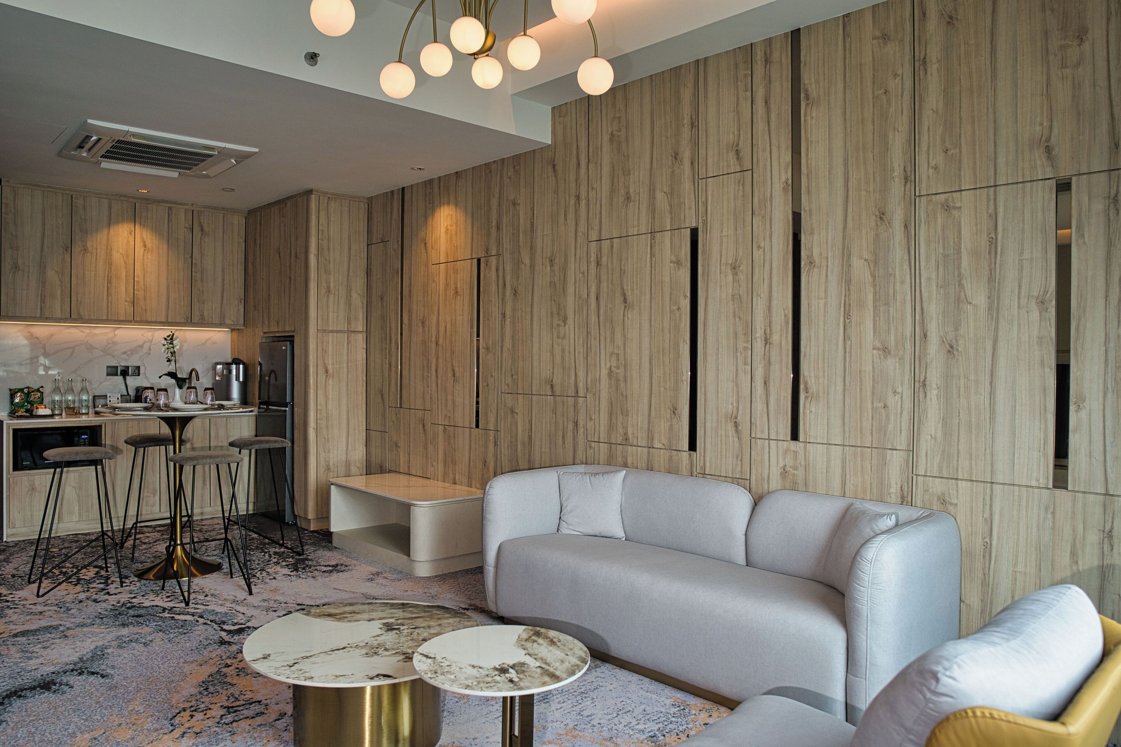 Una cocina moderna con armarios de madera, una barra y una zona de estar con sofá y mesa de centro.