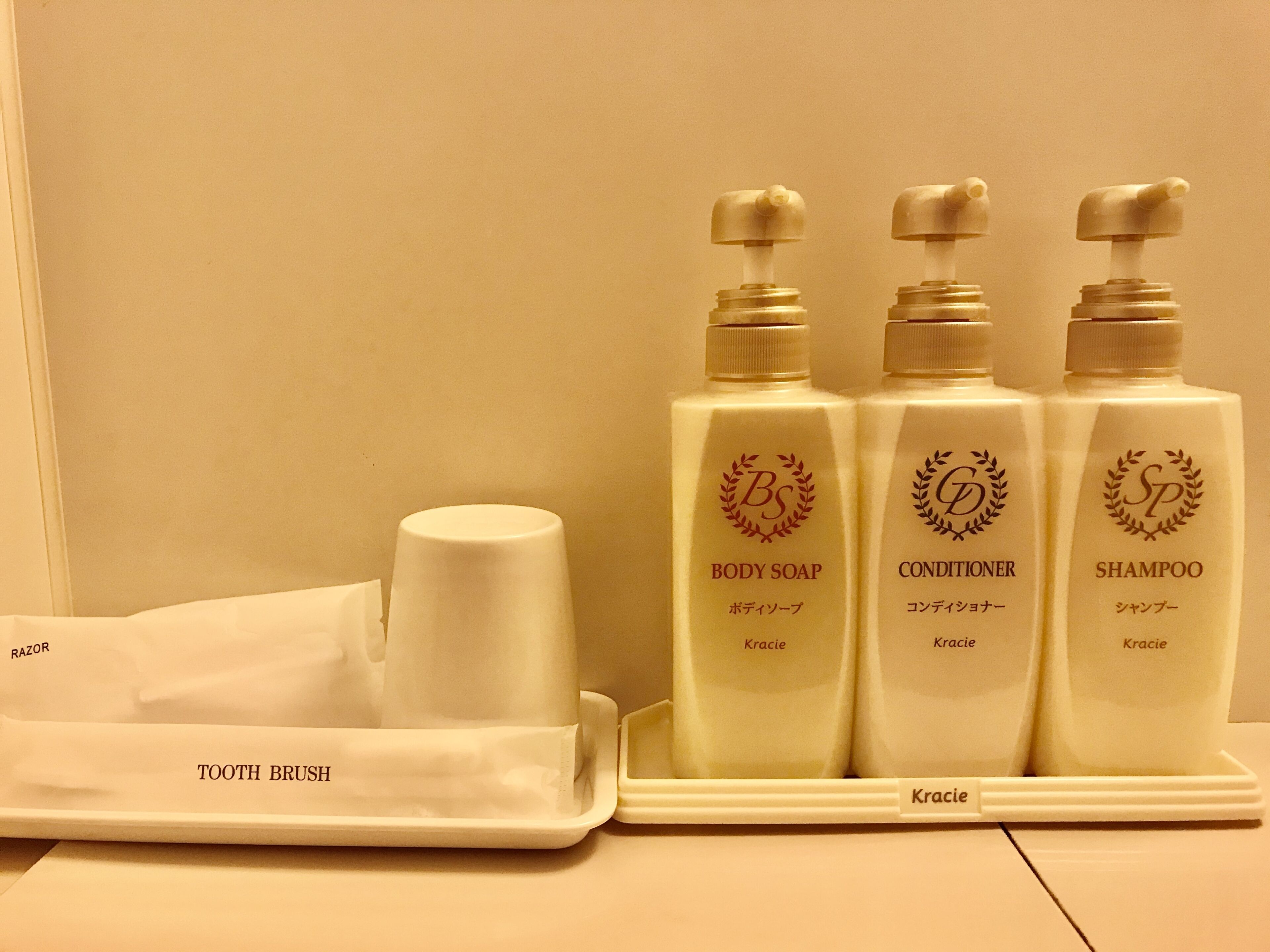 A tray with a razor, body soap, conditioner, and shampoo.