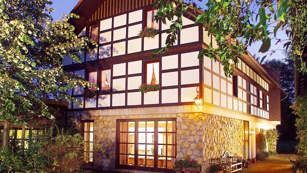 Un bâtiment à deux étages doté d’une façade en pierre et de grandes fenêtres.