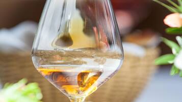 Una copa de vidrio transparente con un líquido dorado, posiblemente vino.