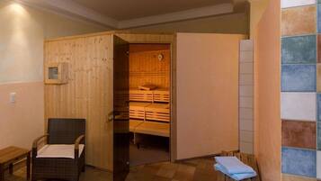 Un sauna avec des bancs en bois et un fauteuil en osier.