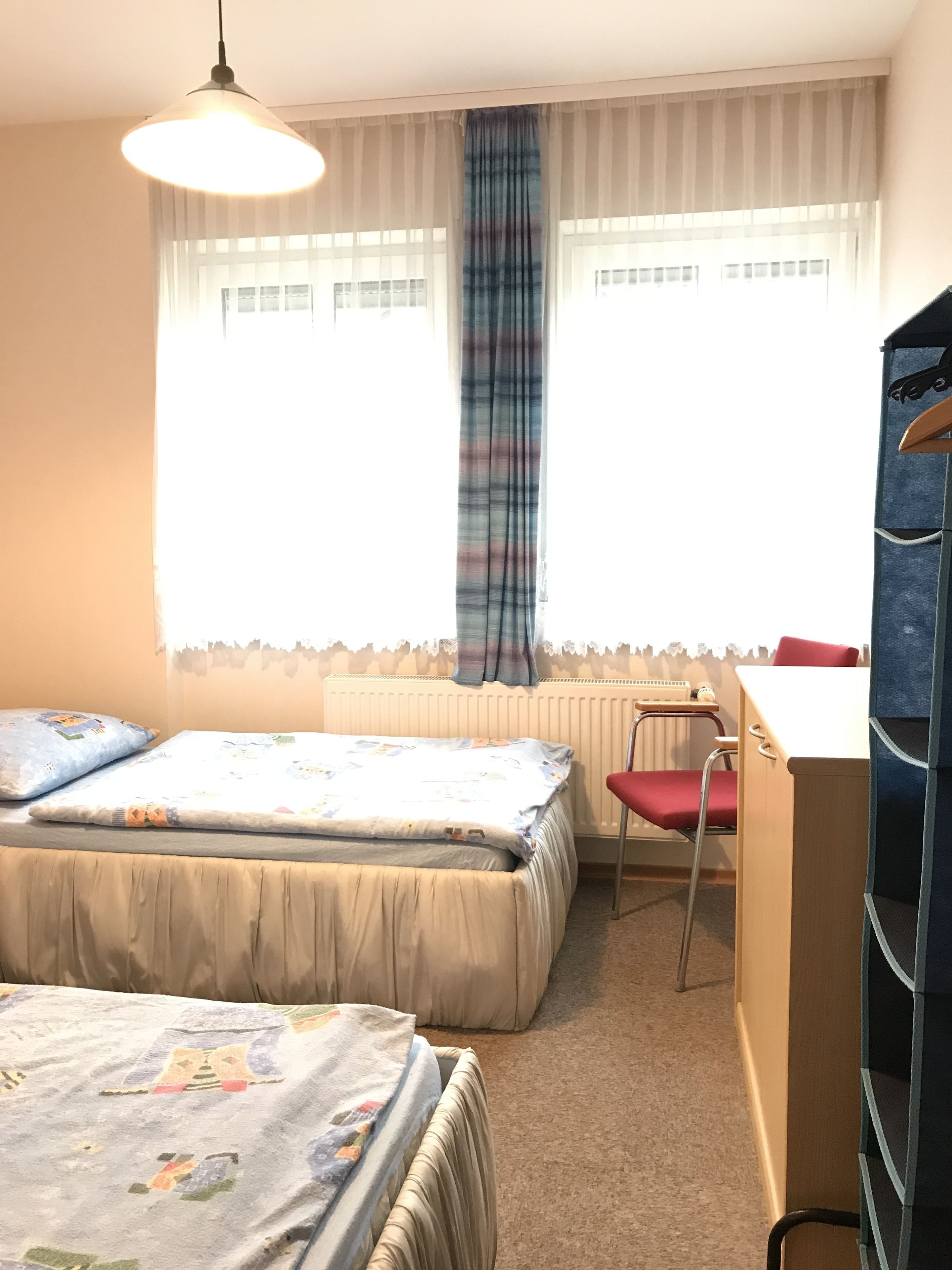 Un dormitorio con dos camas, un escritorio y una silla.