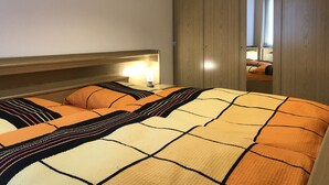 Une chambre à coucher avec un lit, une table de chevet, une lampe et une armoire.